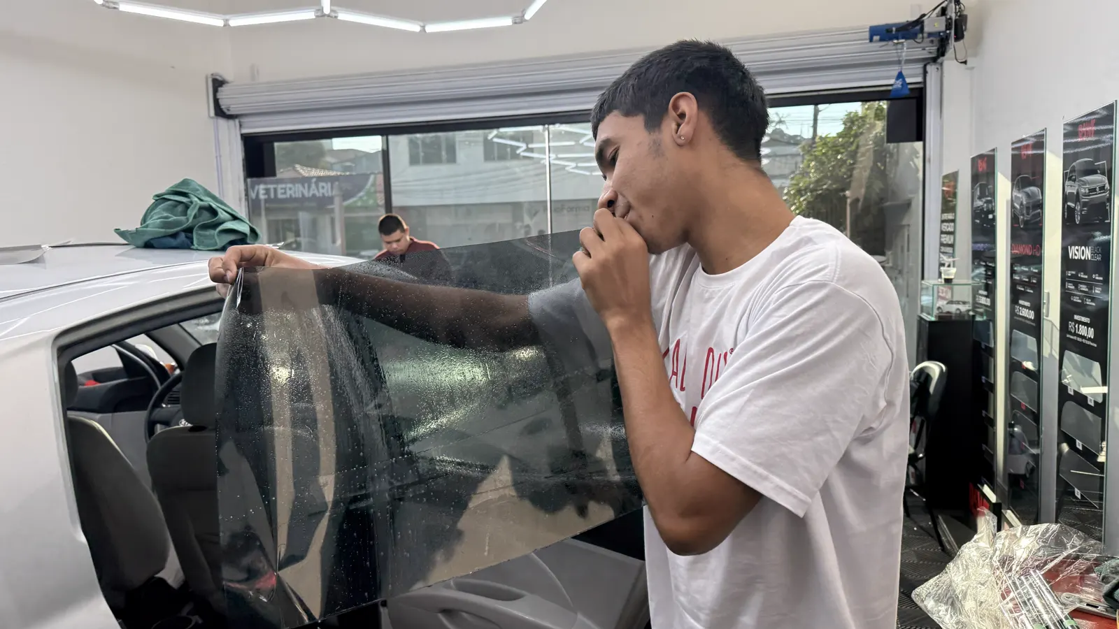 Aluno praticando aplicação de película automotiva